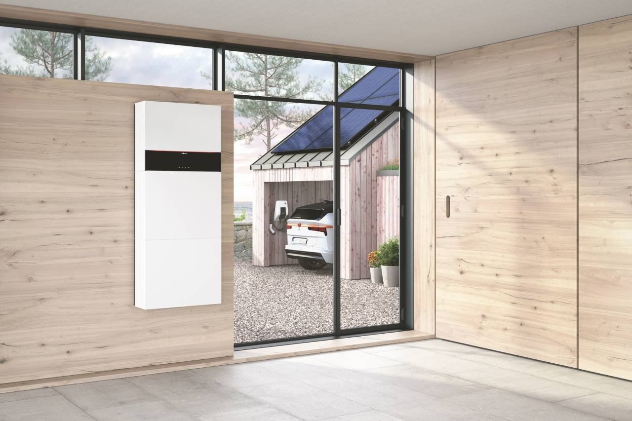 Viessmann Vitocharge VX3 mit Batteriespeicher an der Wand, draußen ein Carport mit Photovoltaik-Modulen